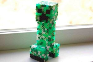 A crafty bead version of a Minecraft Creeper staring ominously, as if contemplating its next move  maybe exploding into thousands of tiny bead pieces.