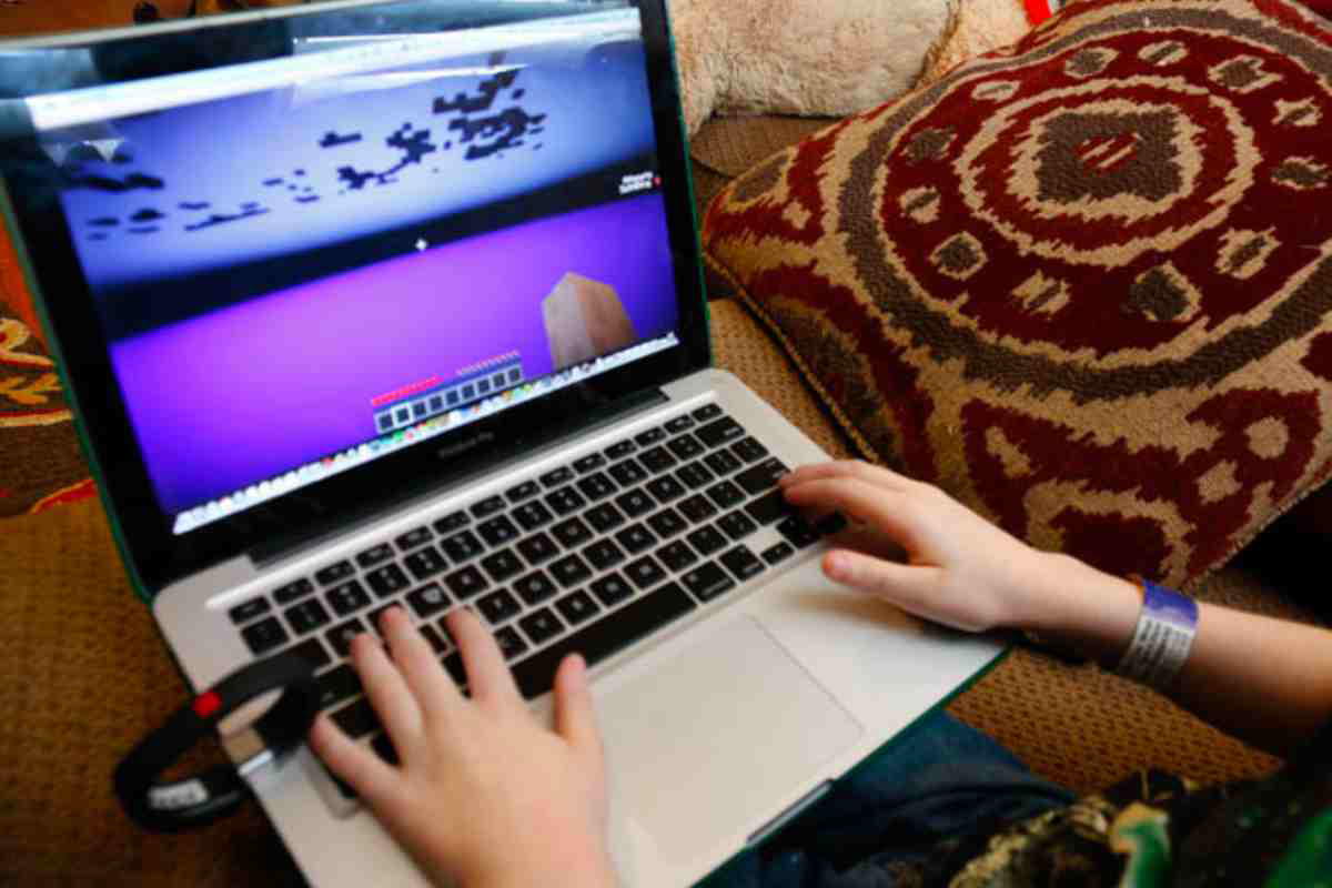 play minecraft levels anywhere Hands of a young gamer, deep in the epic world of Minecraft on a laptop, contemplating whether to build a castle or accidentally dig straight to lava.