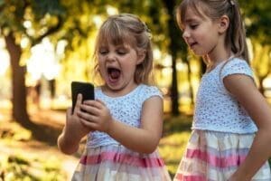 cell phone etiquette for kids 2 girls playing on a cell phone making funny faces