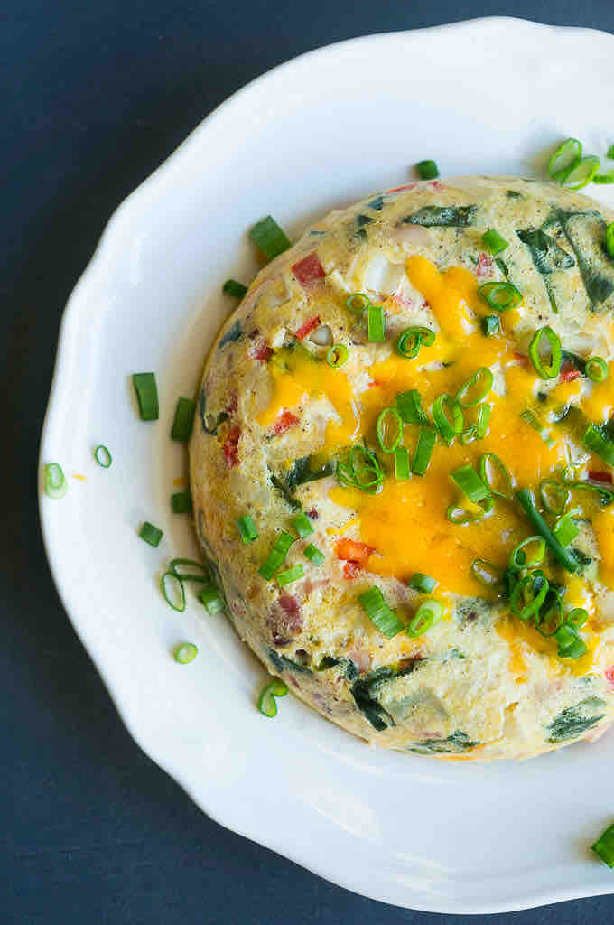 Cheese egg breakfast instant pot recipes A perfectly fluffy egg mug masterpiece topped with melted cheese and green onions, showcasing the art of not burning a breakfast while multitasking.