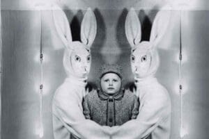 In a classic Easter meme scenario, a child stands between two people in slightly eerie bunny costumes, giving 'eggcellent' vintage vibes and probably questioning all their life choices involving chocolate and cuddly rabbits. Let's just say the Easter Bunny had an off day!