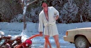 Hilarious Christmas Vacation meme featuring a man in a bathrobe holding a hose, surrounded by snow, illustrating epic holiday chaos.