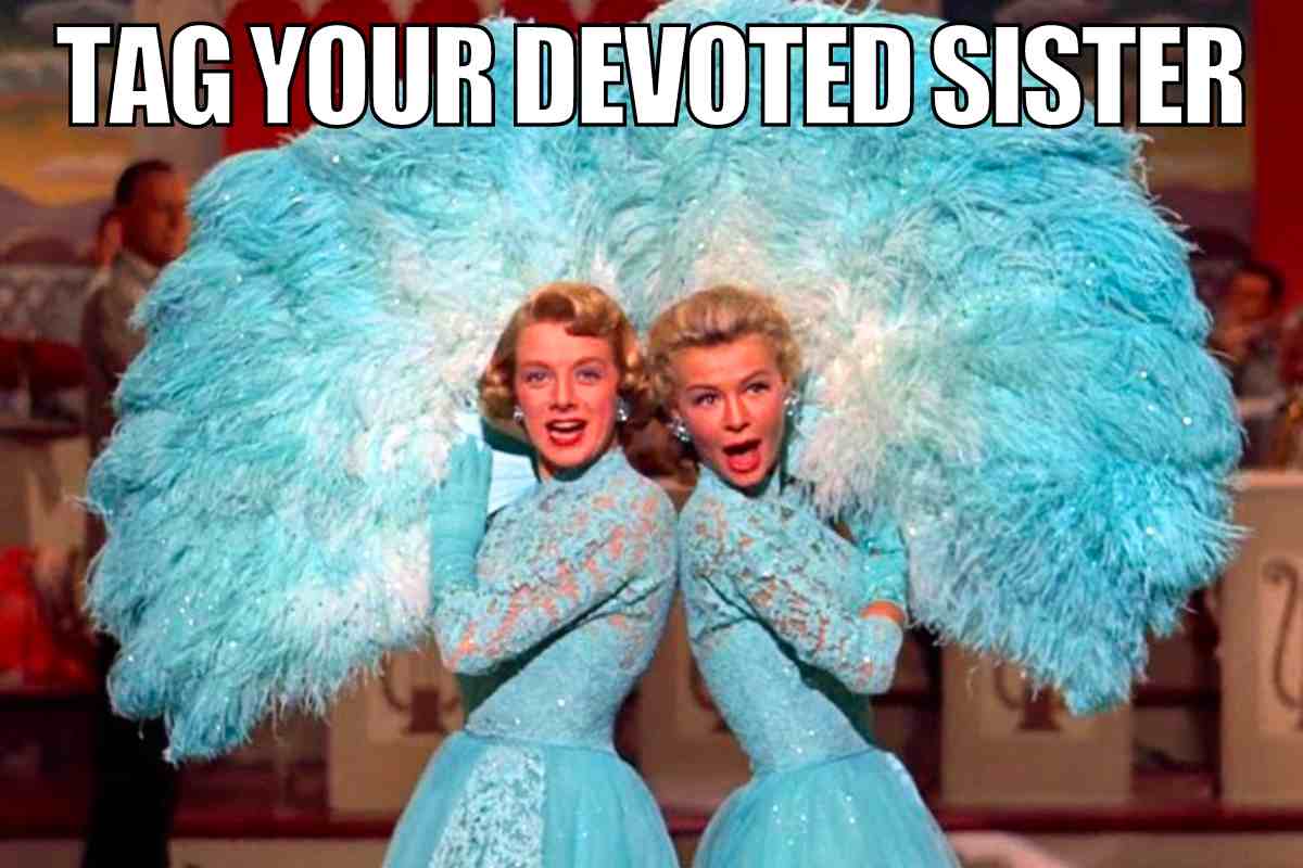 Two glamorous women in sparkling blue dresses and feathered fans strike a pose, with the text 'Tag Your Devoted Sister,' capturing the essence of sibling shenanigans and sister memes about their endless support, even when you're acting extra.
