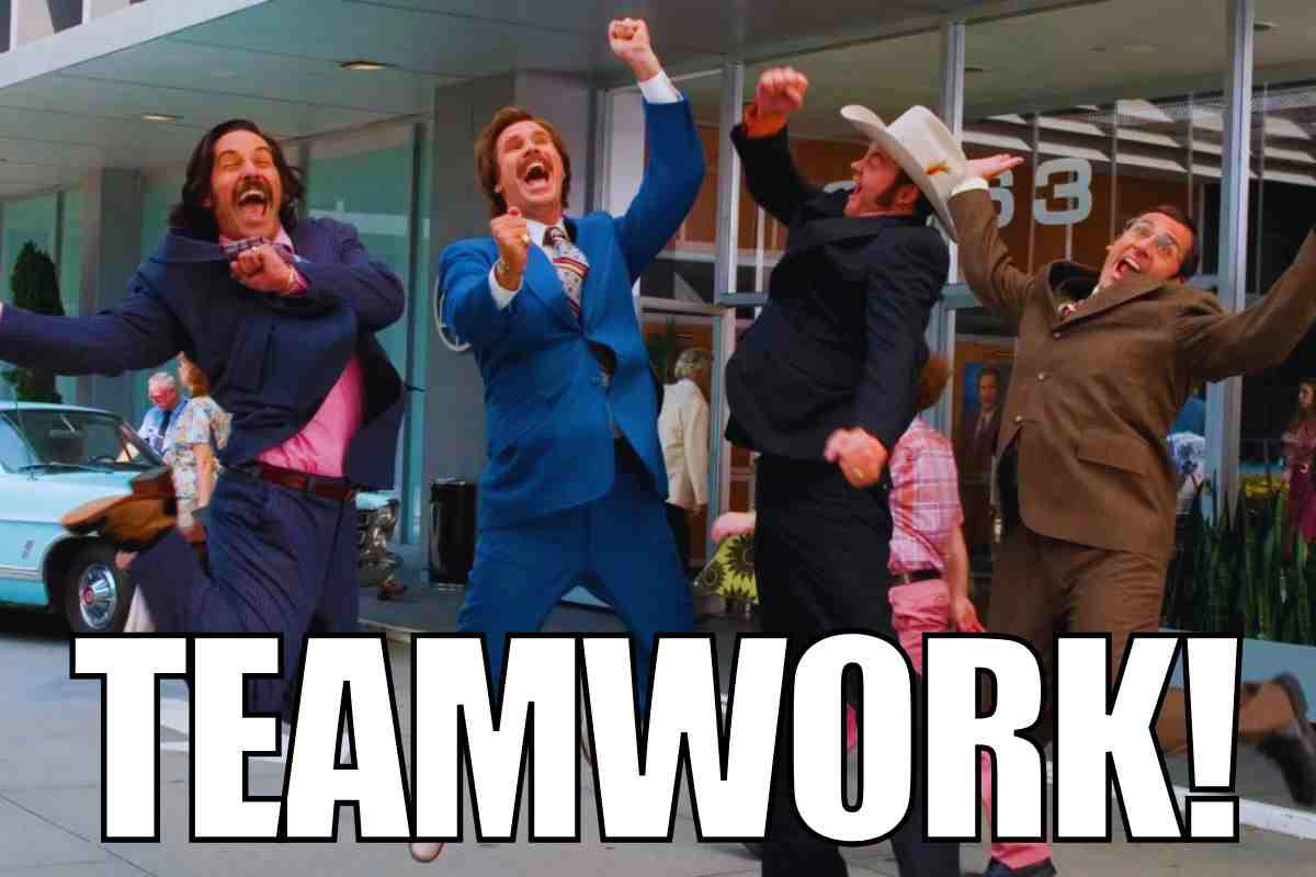 teamwork meme funny A meme showing four jubilant men in business suits jumping with excitement outside an office building, with bold text saying 'TEAMWORK!'—when office synergy means synchronized leaping.