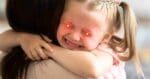 Meme of a young girl hugging someone tightly with glowing red laser eyes, humorously capturing the fierce determination of kids when bedtime is mentioned.