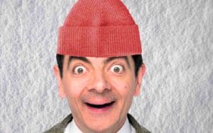 Meme of a wideeyed, surprised man wearing a red beanie against a snowy background, humorously expressing the excitement of winter or impending snowstorm.