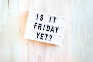 A lightbox sign asks, 'Is It Friday Yet?', the universal mantra for those trudging through the week, dreaming of TGIF—and the only time subtly tapping your watch means something hilarious.