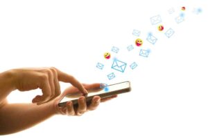 A funny email meme showing a hand eagerly tapping a smartphone as colorful emails and playful emojis joyfully fly out in a digital parade, capturing the chaos of an overflowing inbox.