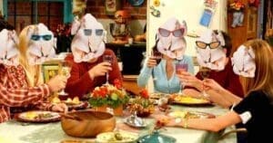 Friendsgiving meme featuring a group of people sitting at a dining table, each with a turkey head sporting sunglasses, raising their glasses to toast humorously.