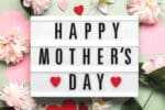 Meme with the text 'Happy Mother's Day' on a lightbox surrounded by flowers and hearts, spreading warm fuzzies like a Hallmark card but with more giggle power!