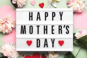 Meme with the text 'Happy Mother's Day' on a lightbox surrounded by flowers and hearts, spreading warm fuzzies like a Hallmark card but with more giggle power!