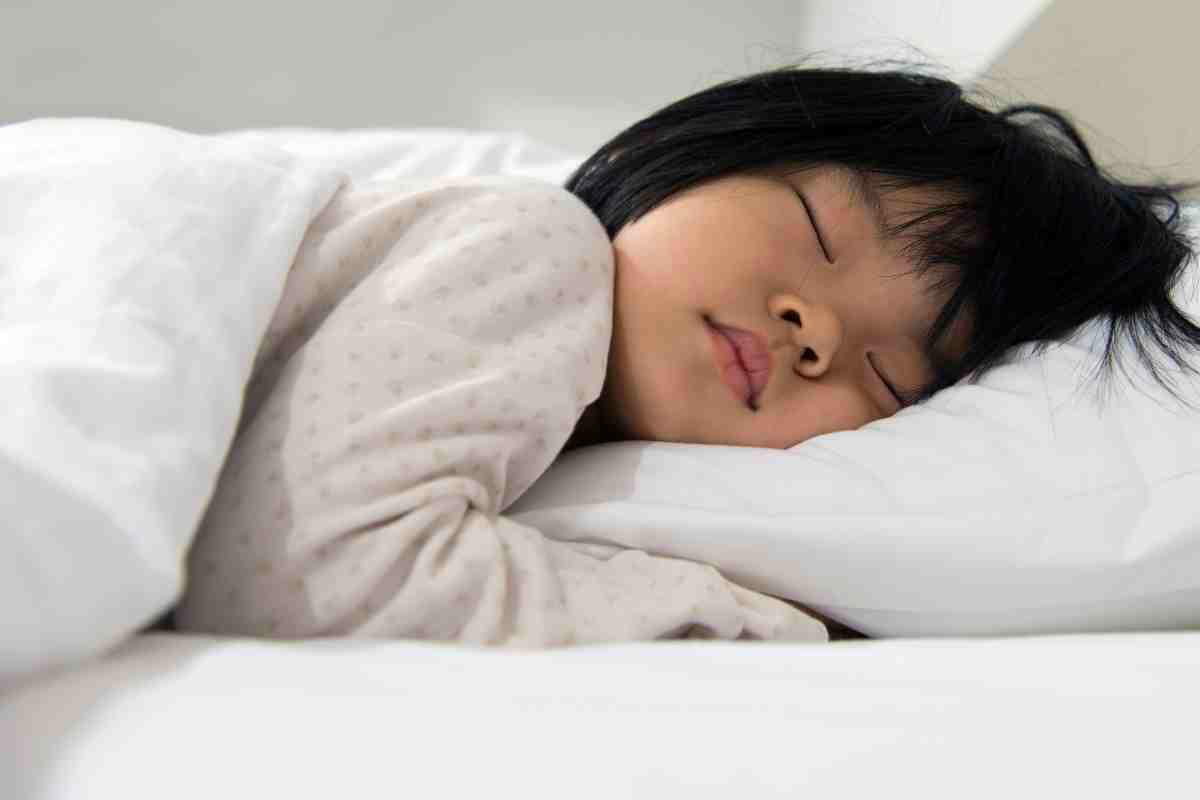 toddler alarm clock for sleep training Peacefully sleeping toddler, ready to activate its built-in early morning alarm clock feature at the first light of dawn.