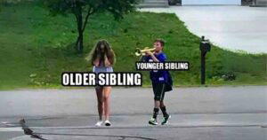 A funny sibling day meme featuring a younger sibling labeled "YOUNGER SIBLING" is playing a brass instrument loudly while an older sibling labeled "OLDER SIBLING" walks ahead covering their ears, appearing annoyed, on a suburban street.