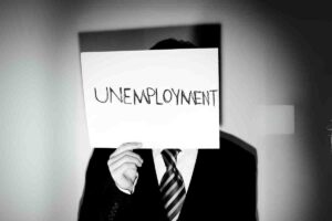 funny unemployed memes showing man holding unemployment sign in a suit