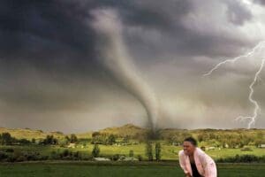 Meme of a woman squinting and struggling to see clearly while a massive tornado looms behind her, as lightning strikes dramatically; a humorous take on life's unexpected chaos.