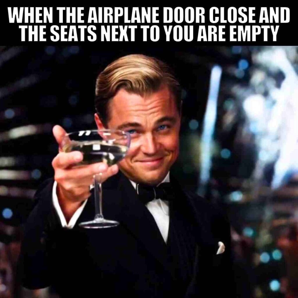Meme of a man in a tuxedo raising a toast with a caption: 'When the airplane door closes and the seats next to you are empty.' Celebrating the rare victory of flying solo.