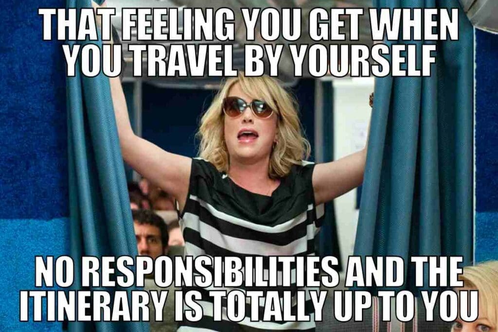 Meme of a woman looking joyful as she spreads her arms, with text humorously proclaiming the freedom and responsibility-free bliss of solo travel.