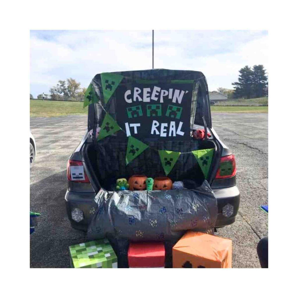 minecraft trunk or treat idea Minecraftthemed car trunk decorated for Halloween with the pun 'Creepin' It Real' and adorned with Creeper faces, perfect for any blockhead who likes their sugar cubed.