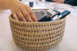 family dinner table with phones stacked in a basket