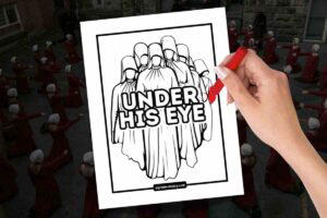A person colors a blackandwhite illustration depicting a group of figures in hooded robes with a bold text saying "UNDER HIS EYE." The background shows several people dressed in red robes and white bonnets kneeling on a street.