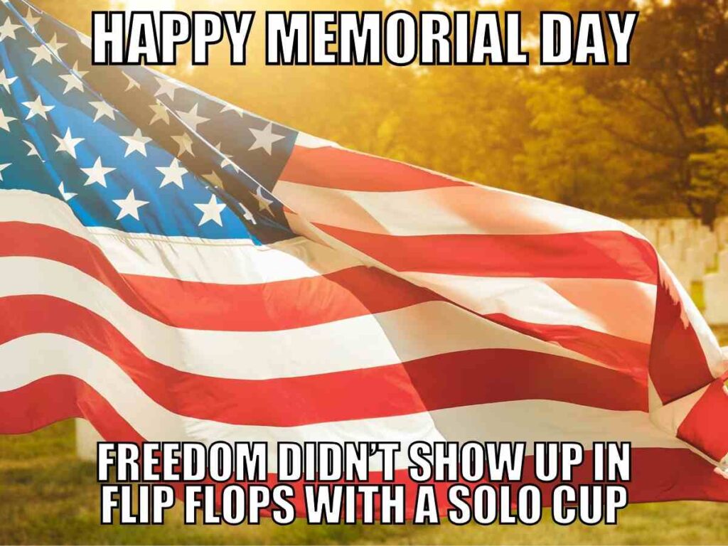 happy memorial day image An American flag waves in the foreground with text reading "Happy Memorial Day" at the top and "Freedom didn't show up in flip flops with a solo cup" at the bottom.